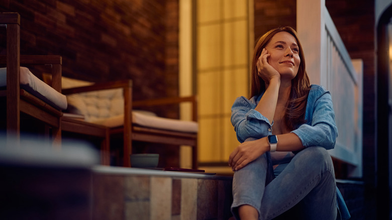 A woman thinks while sitting on her porch