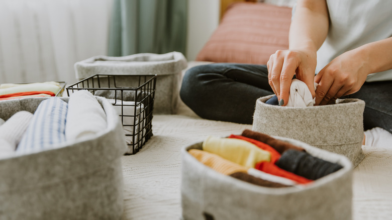 Person organizing items into various small organizational containers