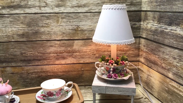 a teacup lamp feature in front of wood wall