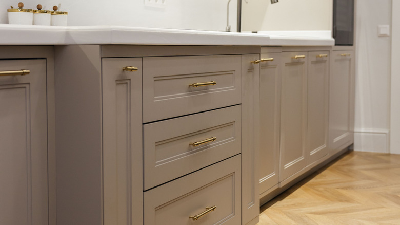 medium taupe kitchen cabinets with brass hardware