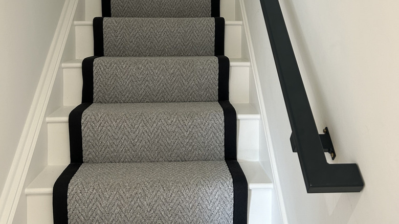 staircase painted white and covered with a runner rug