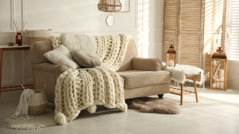 a cozy living room with a large cream-colored throw on the couch