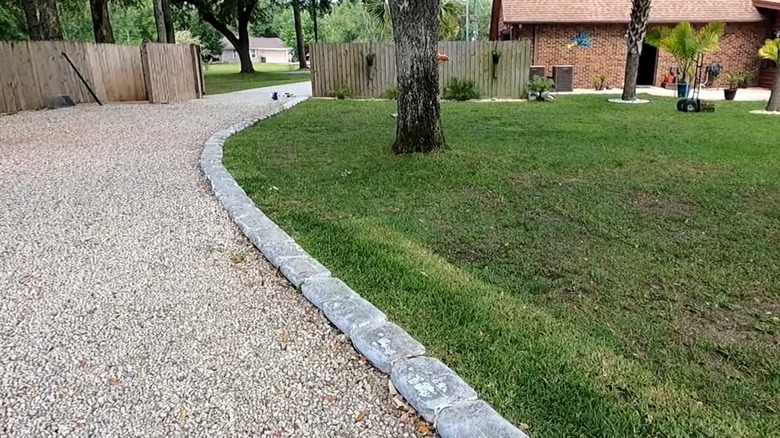 Concrete bag border on gravel driveway with house in the background
