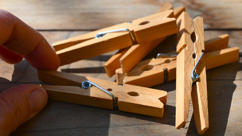 Close up of a person picking up a wooden clothespin