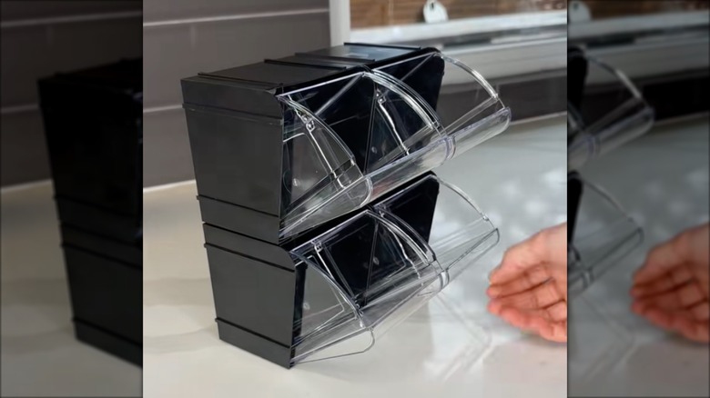 Woman setting up Dollar Tree organizers over indoor white countertop with dark gray backsplash