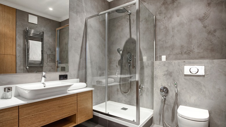 a modern shower with groutless marble slab walls