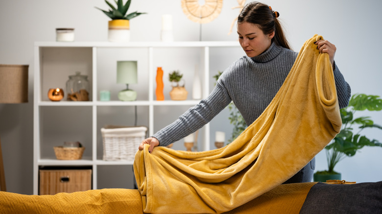 Woman folding golden blanket