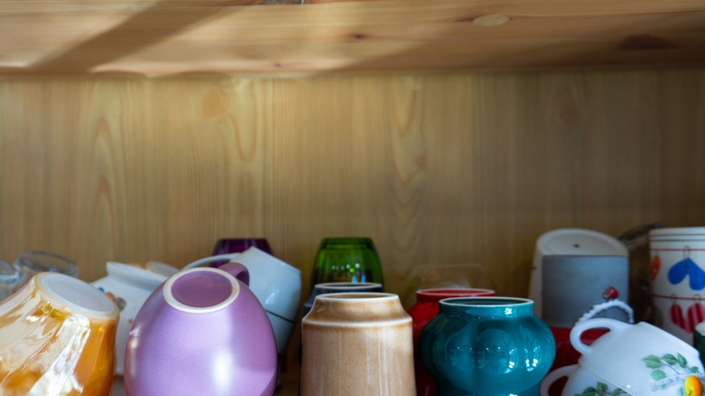 Coffee mugs arranged in a cupboard.