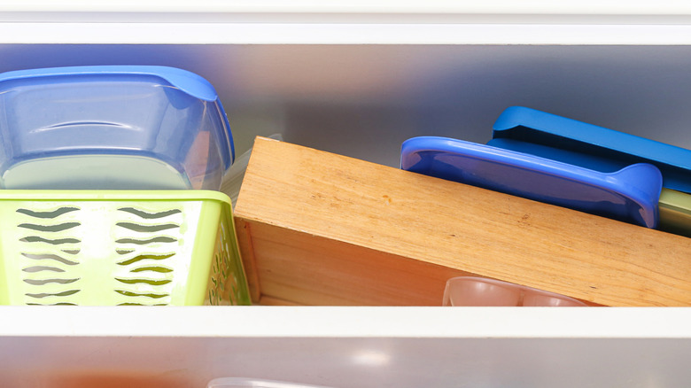 Food storage container lids piled into cabinet
