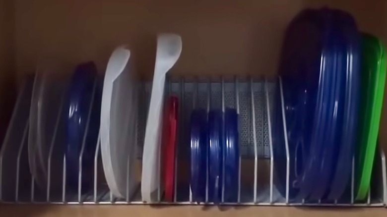 Metal CD rack with plastic container lids in each slot
