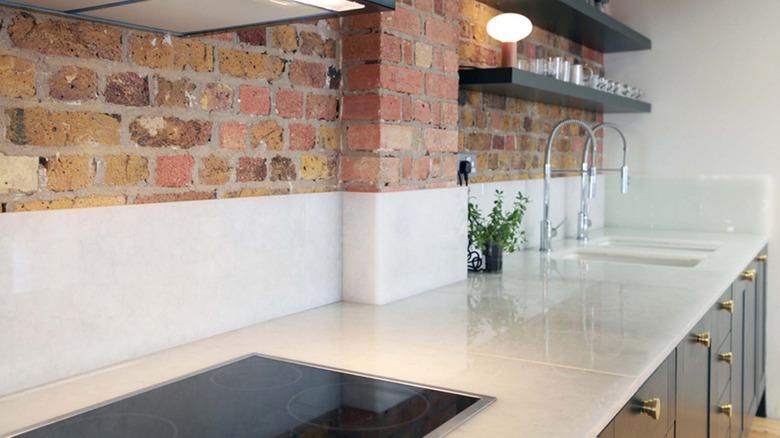White Bio-Glass counter with brick wall and sinks