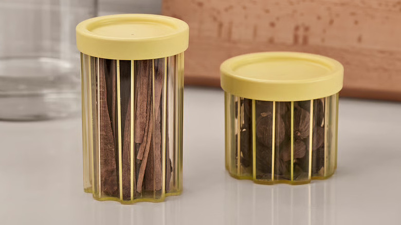 Two yellow IKEA SPJUTLILJA jars with lids on kitchen counter