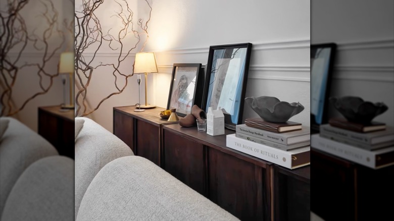 IKEA IVAR sliding door cabinets stained dark and lined up behind a sofa as a sideboard