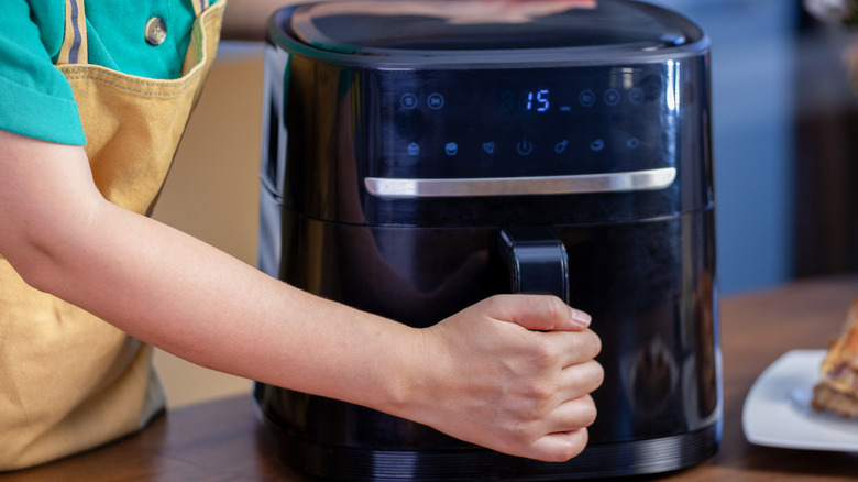 Person using air fryer to cook food