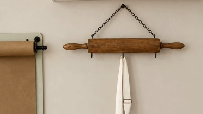 Rolling pin rack holding apron suspended from chain