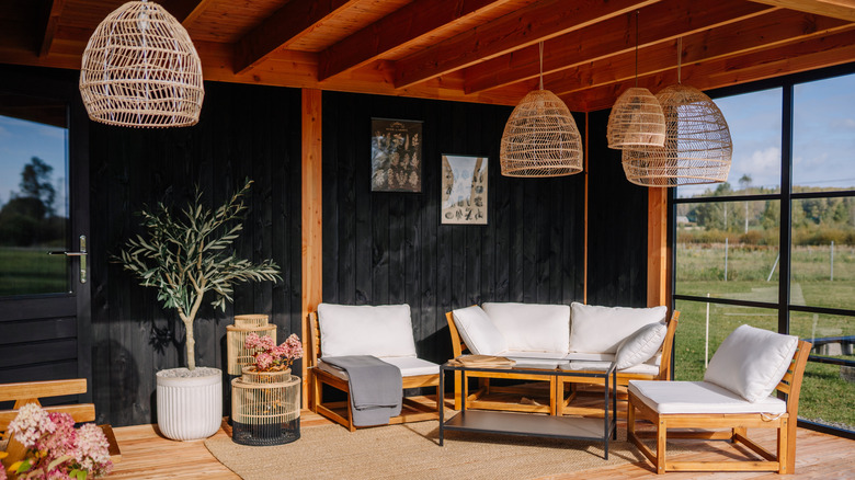 Black wood paneling on a patio with wooden furniture