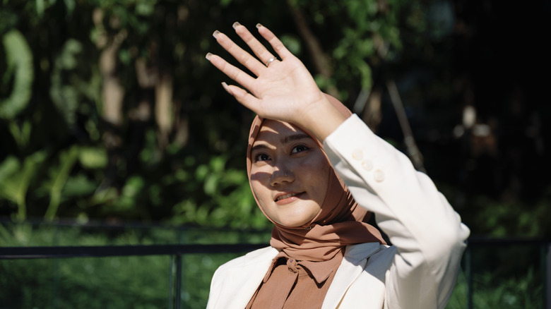 A person shielding their eyes from the sun