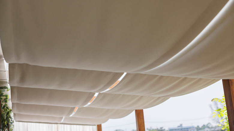 Off-white Roman shades draping over patio