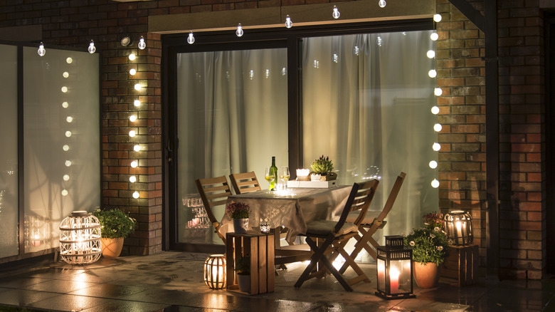 Outdoor patio seating area with string lights and lanterns