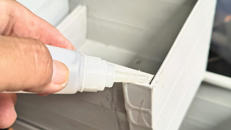 Person applying super glue to a repair project