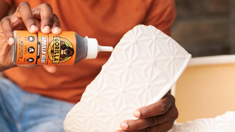 Hand repairing broken ceramic with Gorilla Glue