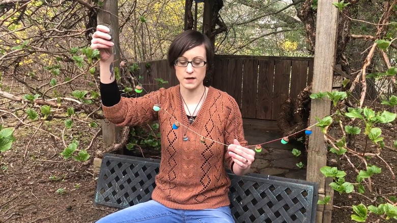 a woman makes a colorful acorn garland