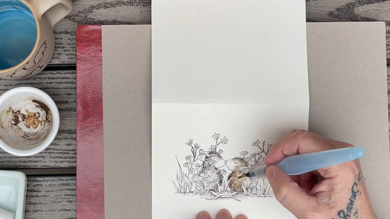 an artist uses acorn ink to draw a picture