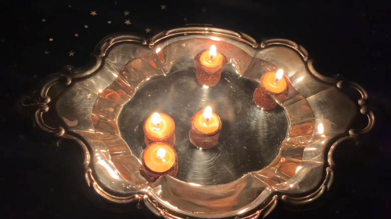 candles made from acorn caps floating in water