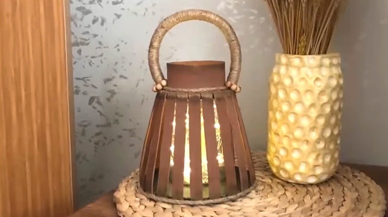 DIY glass jar lantern with fairy lights sitting on tabletop