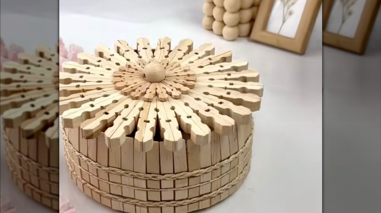 A wooden basket made from clothespins with a circular lid