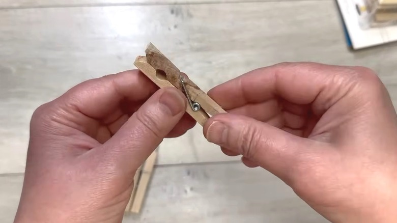 Person taking a clothespin apart