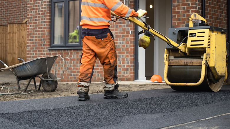 Construction worker rolling out an asphalt surface
