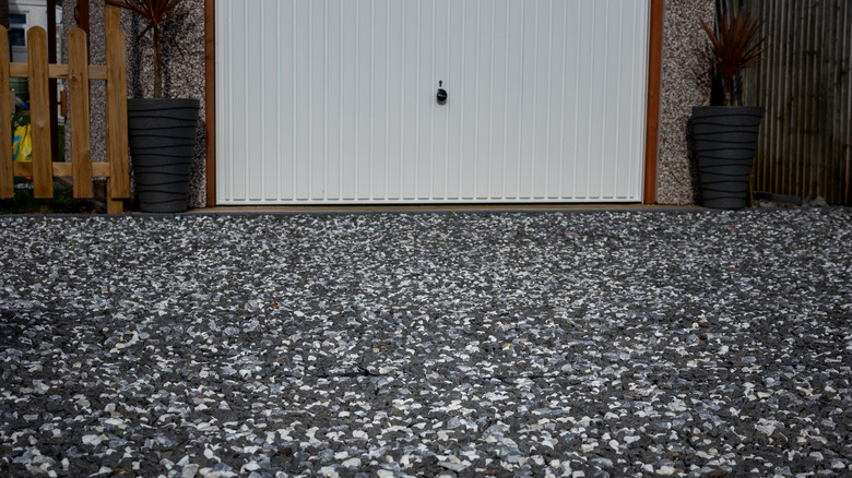 A gravel driveway in front of a garage.