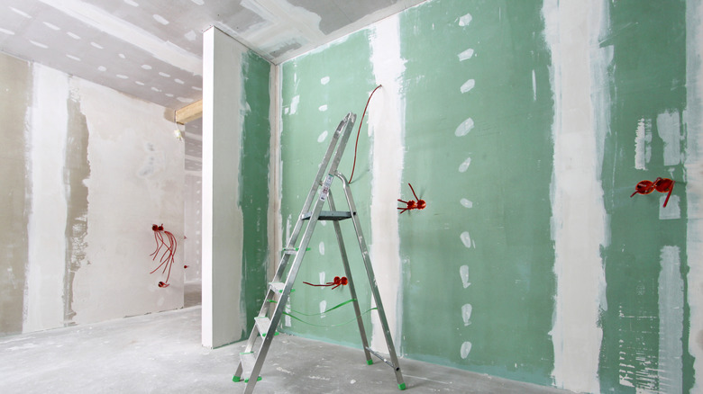 Interior of house under construction with green drywall on the walls