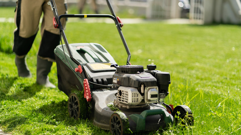 Person mowing with a walk behind mower
