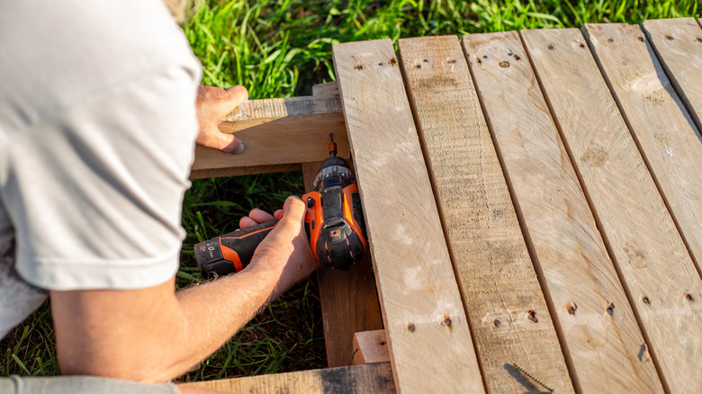 person screwing together pallet wood