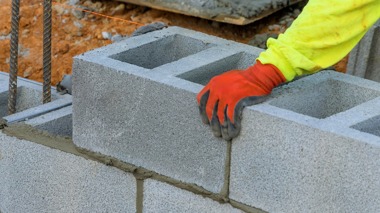 Person laying concrete block foundation