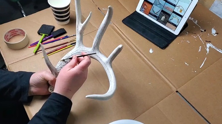 Person painting shed deer antler to make a craft