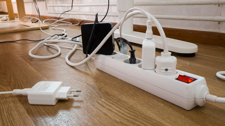 EU outlet power strips on wood floor with plugs and cords