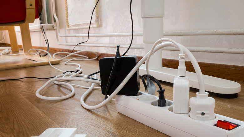Chargers plugged into power strip with cord clutter in background