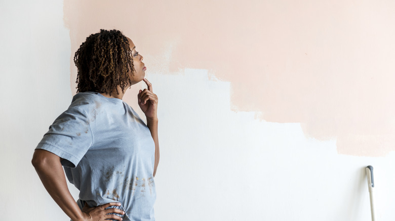 A woman contemplating after painting her walls pink