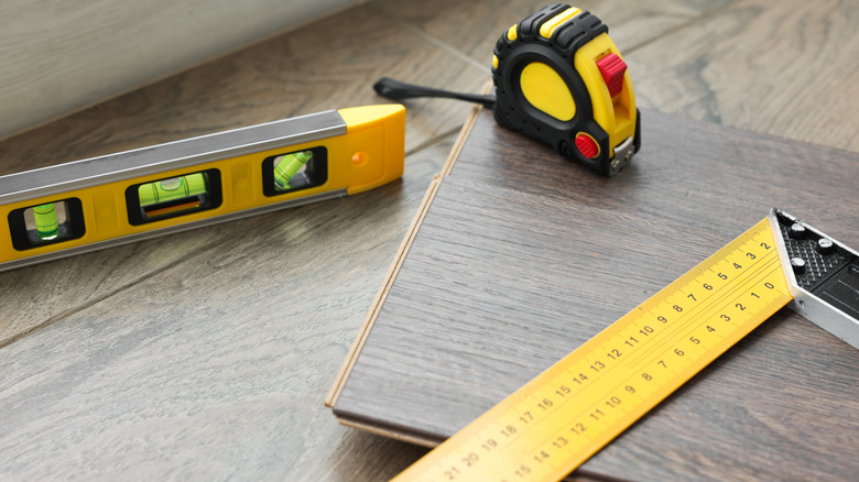 Measuring tools on top of a brand new floorboard