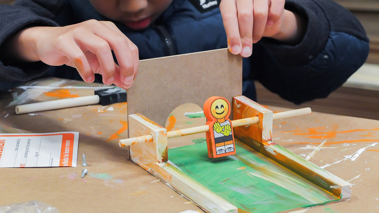A kid working on a craft project at a store