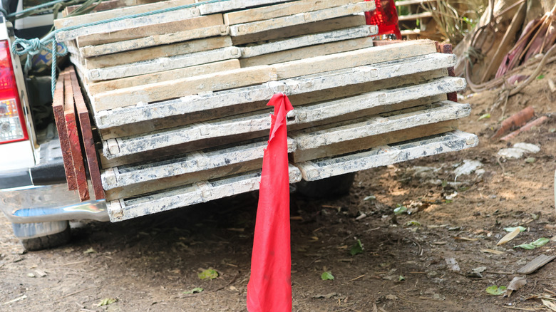 A red flag tied to an oversized load in the back of pickup truck