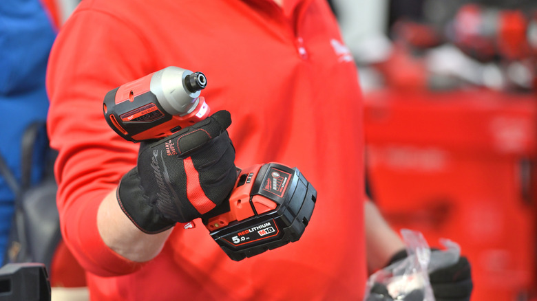 Man holding a Milwaukee-brand power tool.