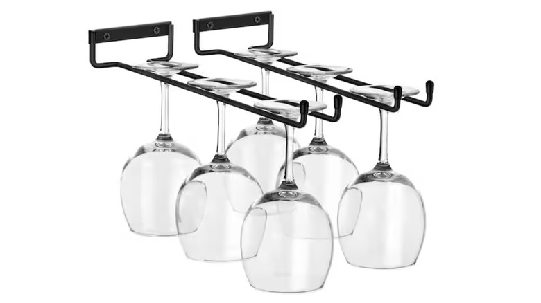 Six wine glasses hanging upside down on two under-cabinet racks