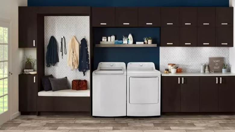 A white washer and dryer sitting beside entryway furniture