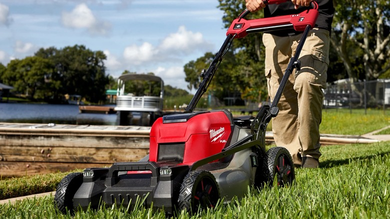 A man using a lawn mower on grass