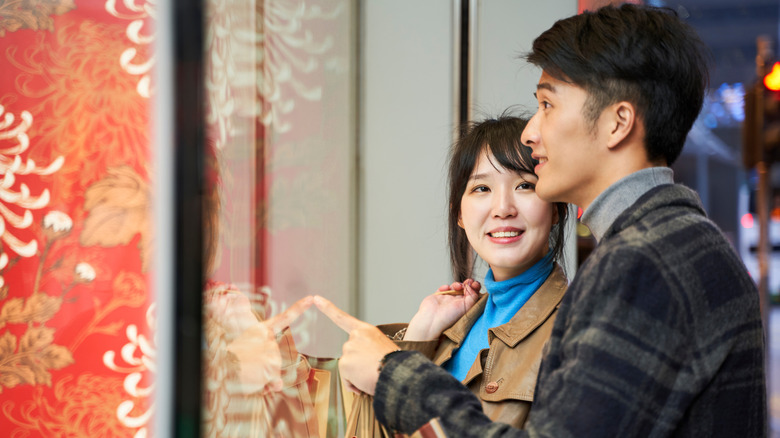 A couple looks through a store window in South Korea