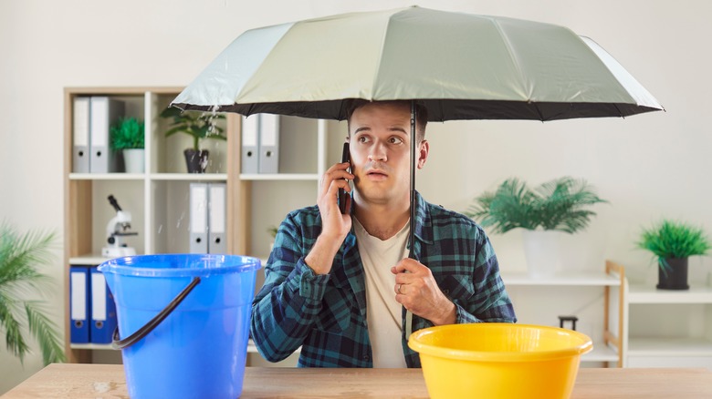 Man sitting at a desk under an umbrella